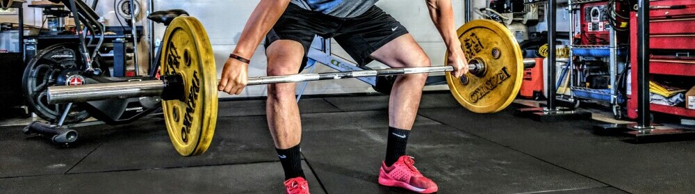 a man doing weighted squats as part of his physical conditioning